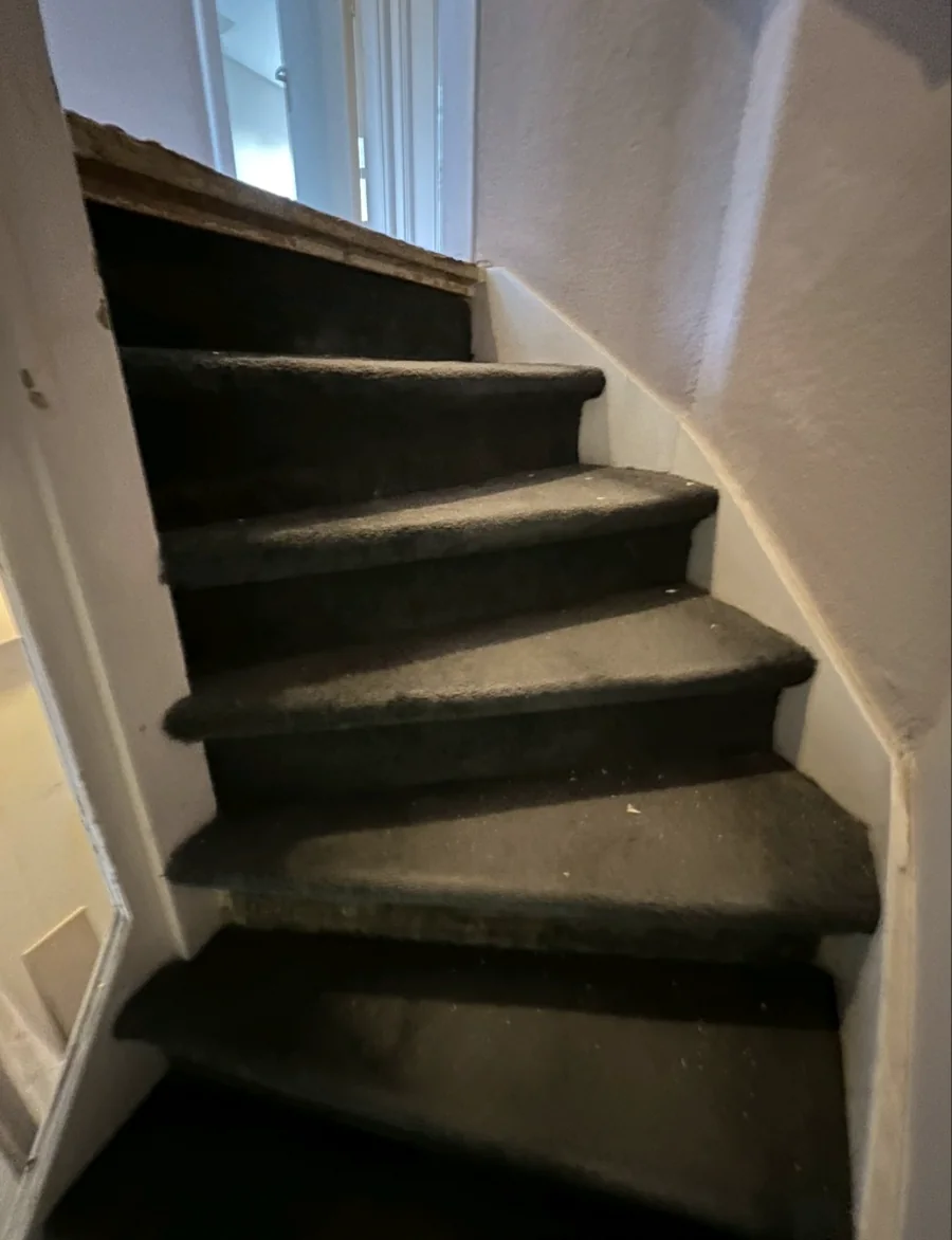 Trap met donkere bekleding vóór de renovatie